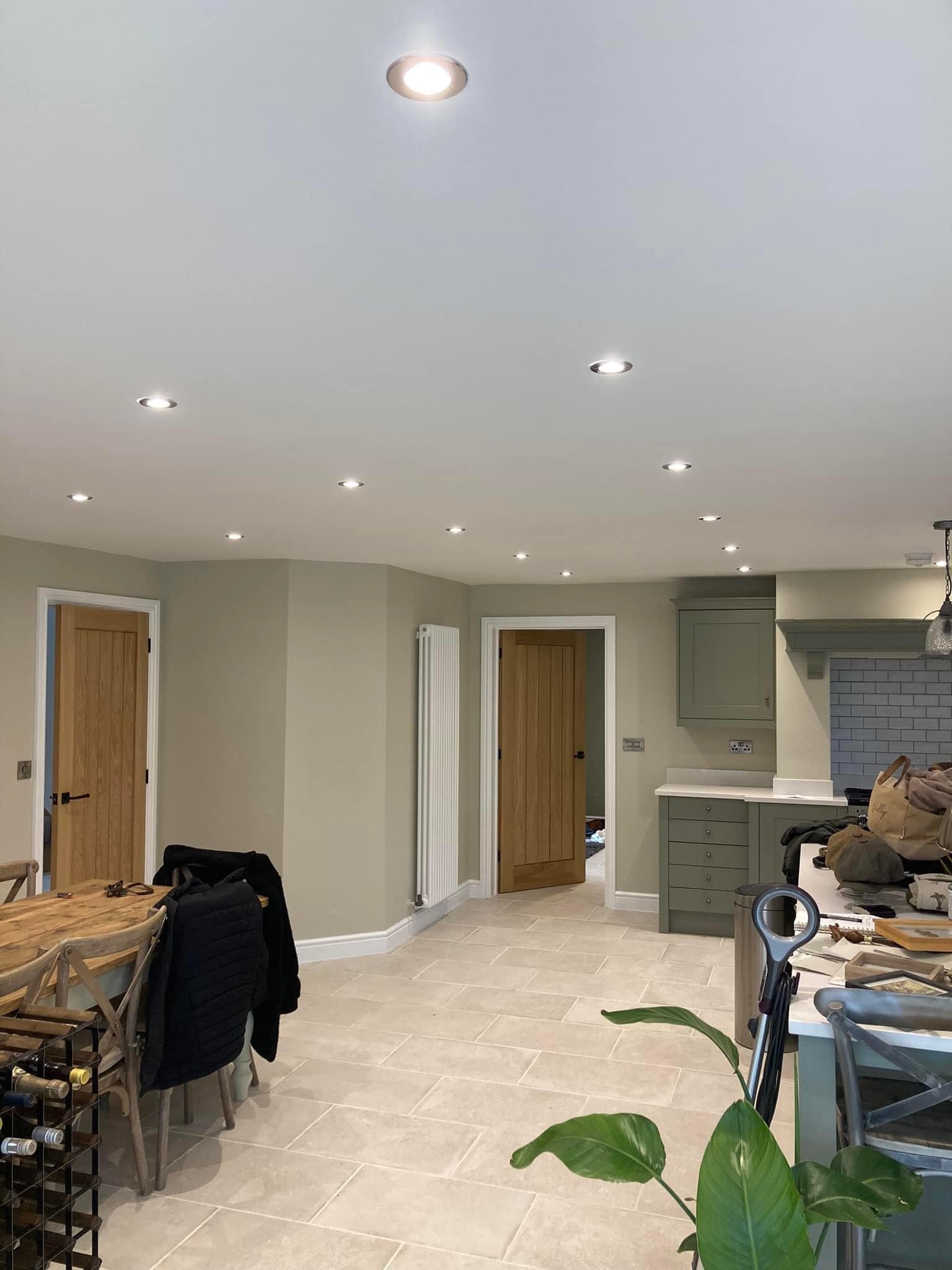 Open-plan kitchen-diner finished in a warm neutral with oak doors